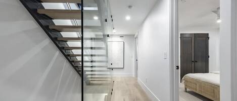 A modern interior with a staircase, a bed, and a wardrobe.