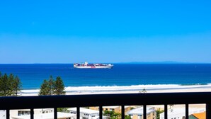 A coastal view with a large cargo ship, beach, and buildings in the foreground. - Centrepoint Unit 58, 30 Minchinton Street, Calound (Caloundra)