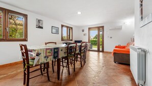 Un comedor con mesa, sillas y vista al exterior.