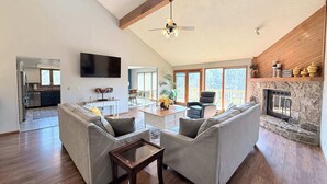 Amplia sala de estar con chimenea, comedor y cocina.