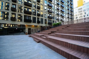 A modern building with multiple balconies, a staircase, and a flat area with a railing. - Studio em frente a UFSC e HU - 625A (Florianópolis)