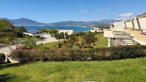 A residential area with a view of the sea, green lawns, and buildings with solar panels. - T2 Porticcio sea view beach on foot (Grosseto-Prugna)