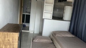 A compact room with a bed, a desk, and a shelving unit. - Container Black  (Rio de Janeiro)