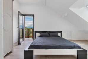 Une chambre moderne avec un lit, une armoire et une vue sur un balcon.