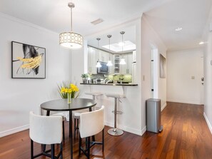 A modern kitchen with white cabinets, a central island, and pendant lighting. - Modern Elegance ~ Excellent Location ~ Steps to the Beach! (Saint Augustine)