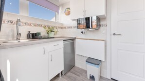 A compact kitchen with white cabinets, a dishwasher, a microwave, and a small trash bin. - Casa Jose 3 Studio with Sea View and Air Conditioning (Torremolinos)