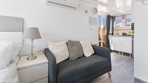 A modern living room with a grey sofa, a lamp, and a white bedside table. - Casa Jose 3 Studio with Sea View and Air Conditioning (Torremolinos)
