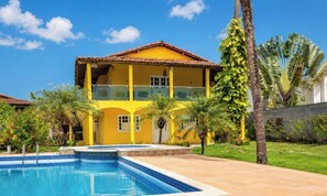 A two-story yellow building with a swimming pool in front. - Casa Sol do Village Na Praia-PS-BA (Porto Seguro)