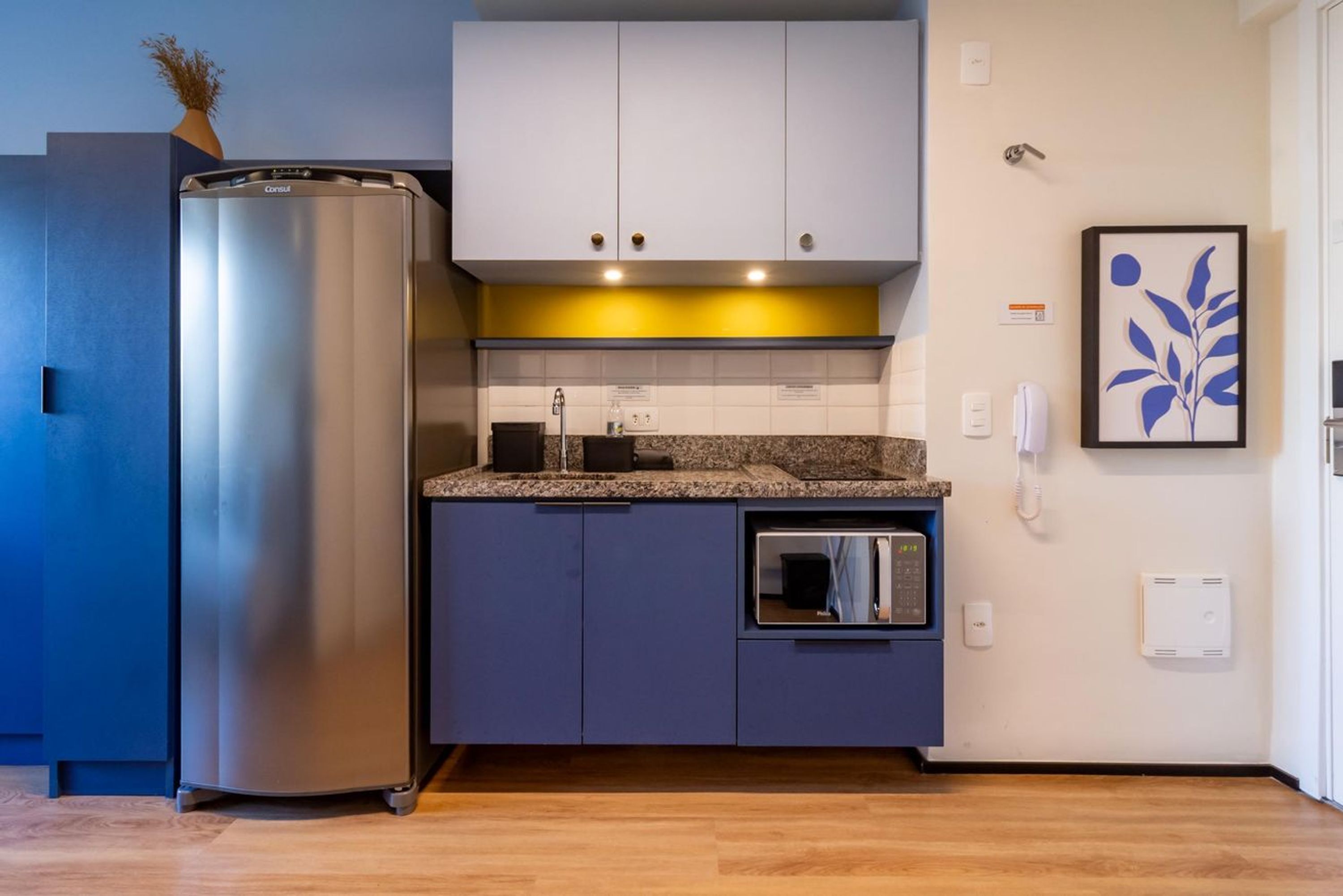 A modern kitchen with a stainless steel refrigerator, a microwave, and a built-in oven.