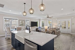 A spacious kitchen with a large island, pendant lighting, and a dining area with a view. - Pool, Spa, Fire Pit, & More at this OKI Escape! (Oak Island)