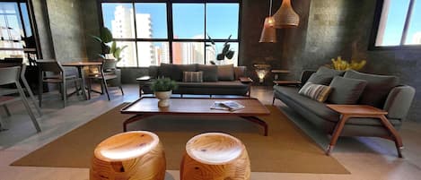 A modern living room with a sofa, coffee table, and two wooden stools.