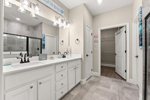 A modern bathroom with a large mirror, dual sinks, and a vanity with drawers. - Beach House - Ocean Breeze Cottage (Port St. Joe)