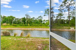 A view of a river with trees and a grassy area. - Beach House - Ocean Breeze Cottage (Port St. Joe)