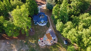 An aerial view of a property with a large house, a circular outdoor area with seating, and a garden. - Zome of the Stars: Private Lakefront AND 2 Acre Pond, Docks, Kayaks, Spa Bath (Mineola)