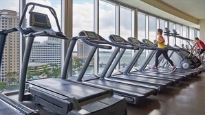 A gym with treadmills, a large window, and a view of buildings. - Deluxe Brickell Suite w/ pool, gym, & city views! (Miami)