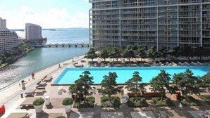 A high-rise building with a swimming pool and lounge area. - Deluxe Brickell Suite w/ pool, gym, & city views! (Miami)