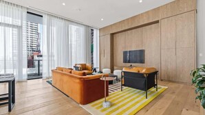 Ein modernes Wohnzimmer mit einer Couch, einem Couchtisch und einem Fernseher.