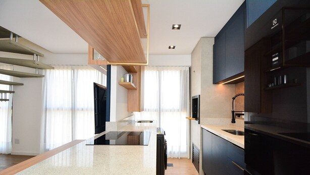 Een moderne keuken met een centraal eiland, inbouwapparatuur en houten accenten.