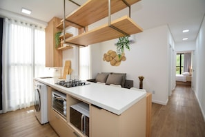Una cocina moderna con electrodomésticos integrados, estructura de techo de madera y vistas al área de estar contigua.