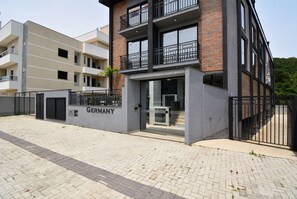 Un edificio moderno con una placa que dice 'GERMANY', entrada de cristal y fachada de ladrillo.