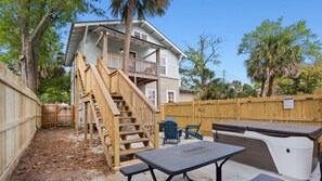 A two-story house with a wooden staircase, a patio with a table and chairs, and a barbecue grill. - NEW!! The Drift -Spa, BBQ, Firepit & Pet Friendly-Dwtn San Marco-Jacksonville (Jacksonville)