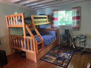 A bunk bed room with a desk, computer, and headphones.