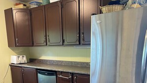 A kitchen with wooden cabinets, a stainless steel refrigerator, and a dishwasher. - 1000 Islands Cottage Rental with sandy beach and amazing view.  Boat access only (Leeds And The Thousand Islands)