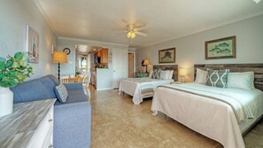 A hotel room with two beds, a sofa, a dining area, and a kitchen. - Gulf View Efficiency by Avantstay. Steps to Beach + Boardwalk 2 Pools + Pickleball Access Coastal Studio (Port Aransas)