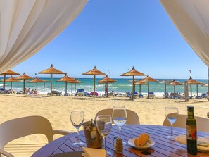 A beachside restaurant with outdoor seating, umbrellas, and a view of the ocean. - Los Monteros Palm Beach, garden & BBQ (Marbella)