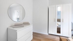 A bedroom with a white dresser, a round mirror, and a wardrobe with a mirrored door. - Apartment Allgäunest Wangen – Stylish Stay for Up to 5 Guests (Wangen im Allgäu)