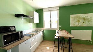 Una cocina con microondas, pileta y ventana.