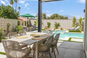 An outdoor patio with a pool, wicker furniture, and a view of the mountains. - 4 Bedroom Luxury Estate With Pool, Spa, & Firepit (Bermuda Dunes)