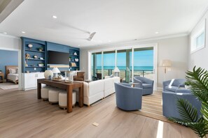 Una sala de estar moderna con un ventanal grande, un comedor y una pared de acento azul.