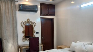 Une chambre d’hôtel équipée d’un lit, d’un bureau, d’une chaise et d’un ventilateur de plafond.