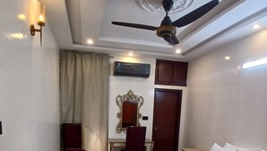 Une chambre d’hôtel équipée d’un lit, d’un bureau, d’une chaise, d’un ventilateur de plafond et d’un appareil de climatisation.