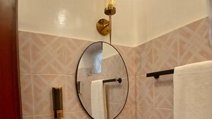 Une salle de bain avec un lavabo rouge, un miroir, un porte-serviettes et un porte-savon.
