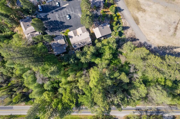 An aerial view of a residential area with houses, a parking lot, and a road. - Bass Lake Retreat w/community Pool/Yosemite & Lake (Bass Lake)