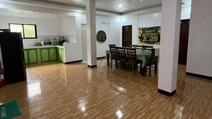 A spacious room with a dining area, kitchen, and a wall with a New Year 2026 decoration. - Comfortable Escape at Yena’s Inn (Cauayan)