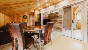Un interior de madera con una mesa de comedor, sillas, un sofá y una chimenea.