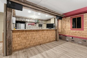 Una cocina con paneles de madera, microondas y lavamanos.