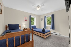 A bedroom with two single beds, a ceiling fan, and windows with curtains. - Vermont Mountain Retreat Near Lake Willoughby (Charleston)
