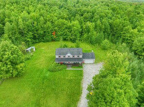 A house surrounded by dense green forest. - Vermont Mountain Retreat Near Lake Willoughby (Charleston)