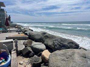 A rocky shoreline with a wooden deck, lounge chairs, and a small pool. - Lux Oceanfront 4-Bed, 3-Bath Beach House. Sleeps 10. Buccaneer Beach, Oceanside (Oceanside)