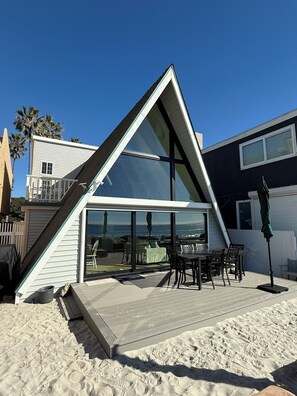 A modern house with a large glass window, a deck, and a view of the ocean. - Lux Oceanfront 4-Bed, 3-Bath Beach House. Sleeps 10. Buccaneer Beach, Oceanside (Oceanside)