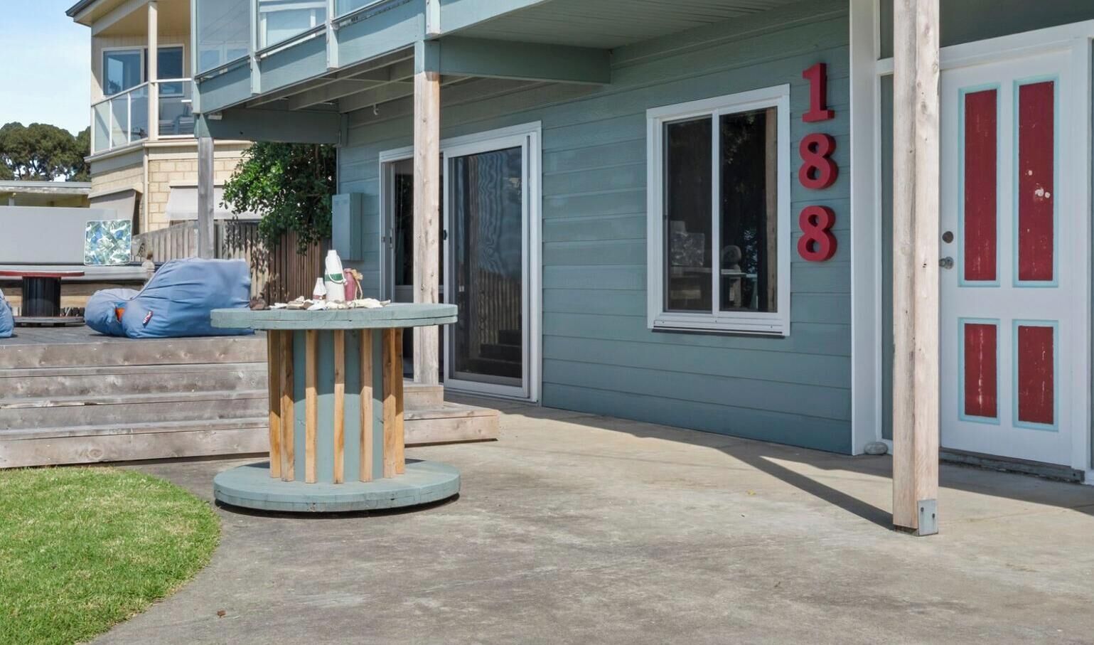 A residential property with a covered patio, a wooden table, and a house number 138.