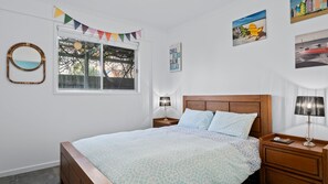 A bedroom with a bed, two bedside tables, a window, and wall decorations. - Esplanade Escape - Beautiful Esplanade Escape in Indented Heads (Indented Head)