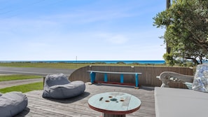 A deck with a view of the ocean, a wooden bench, a round table, and a sofa. - Esplanade Escape - Beautiful Esplanade Escape in Indented Heads (Indented Head)