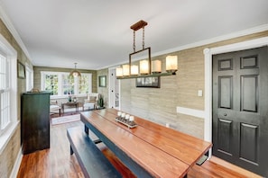 A kitchen with a wooden table, pendant lights, and a dark door. - Five Pines Lodge ATV & Snowmobile Friendly (Coudersport)