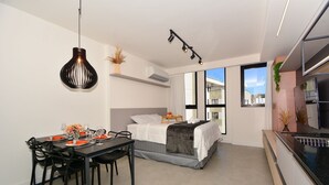 Un dormitorio moderno con una cama, mesita de noche y ventana.