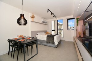 Un dormitorio moderno con una cama, mesita de noche y ventana.